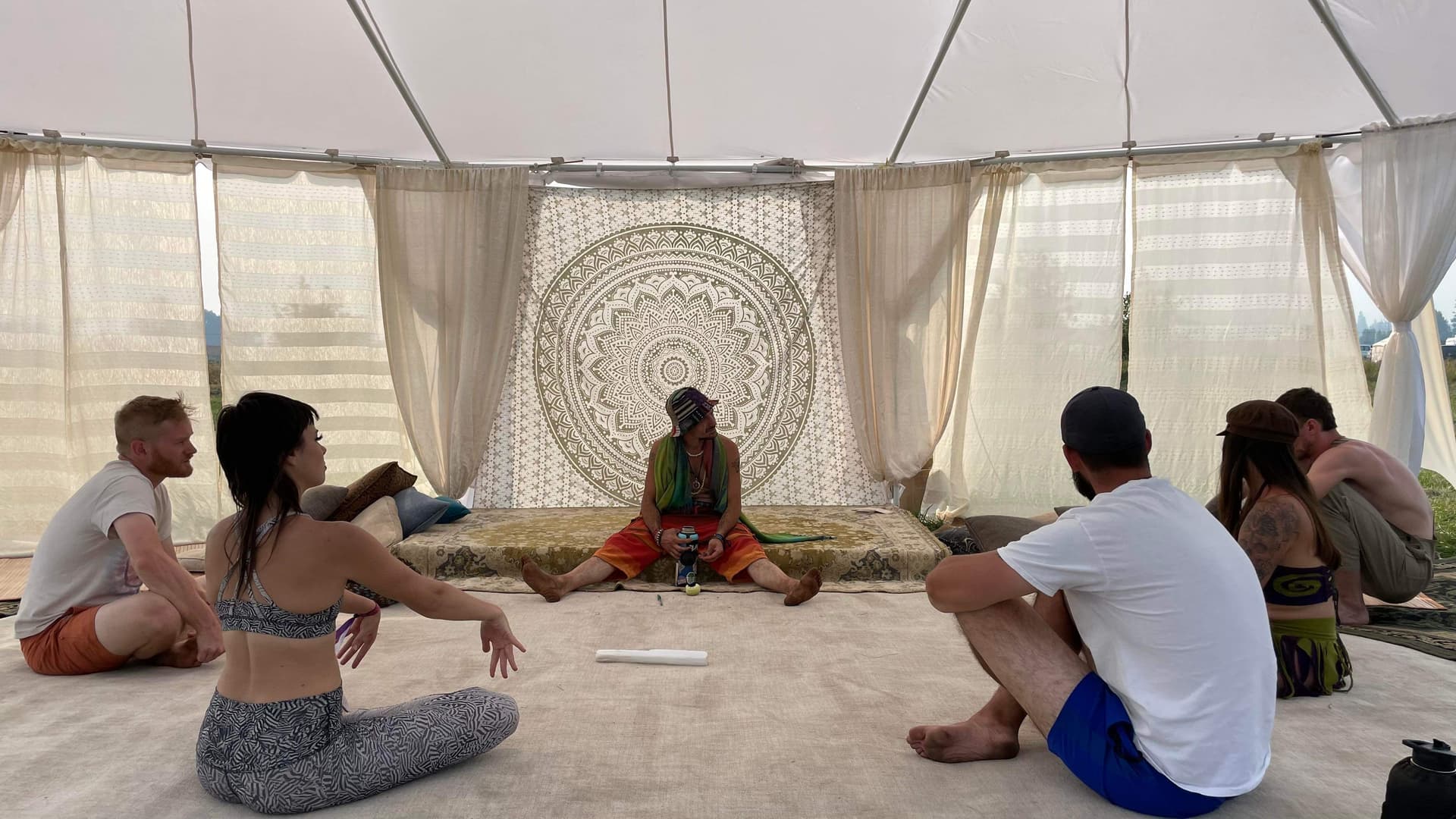 Participants in an embodied practice session under a tent